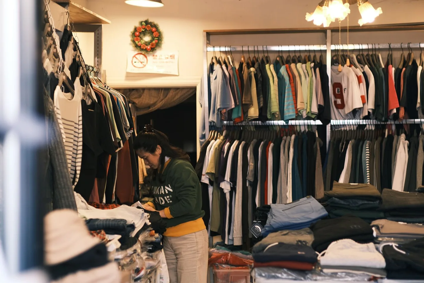 A shop worker arranging clothes in an independent clothing store.